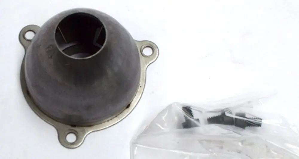 Luftdüse von Daikin, rund mit Anschlusslöchern, in mattem Schwarz. Neben der Düse befinden sich mehrere schwarze Schrauben in einer durchsichtigen Verpackung.